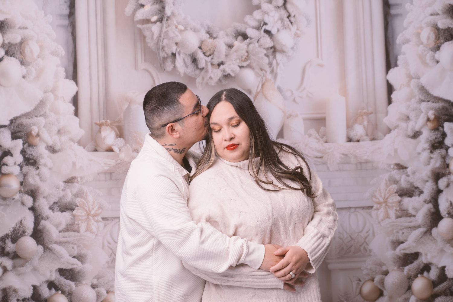 Intimate winter portrait session with white flocked Christmas trees and wreaths.