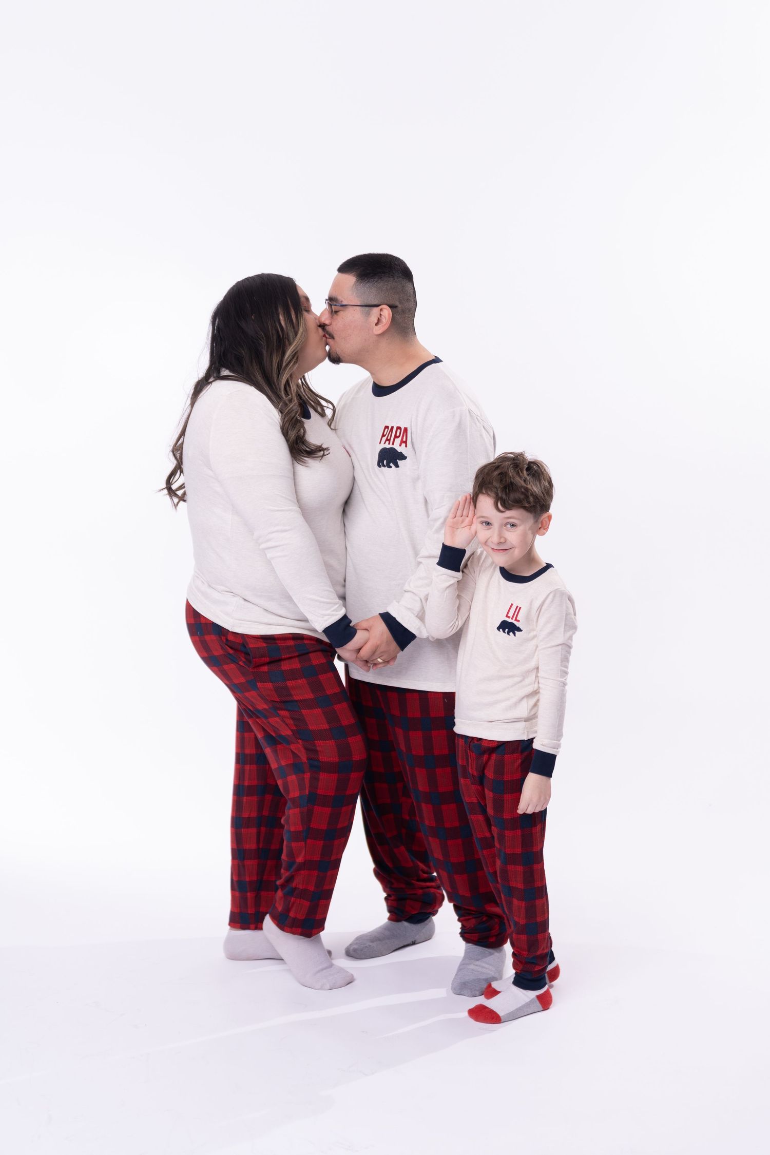 Sweet family moment captured against clean white background in matching outfits.