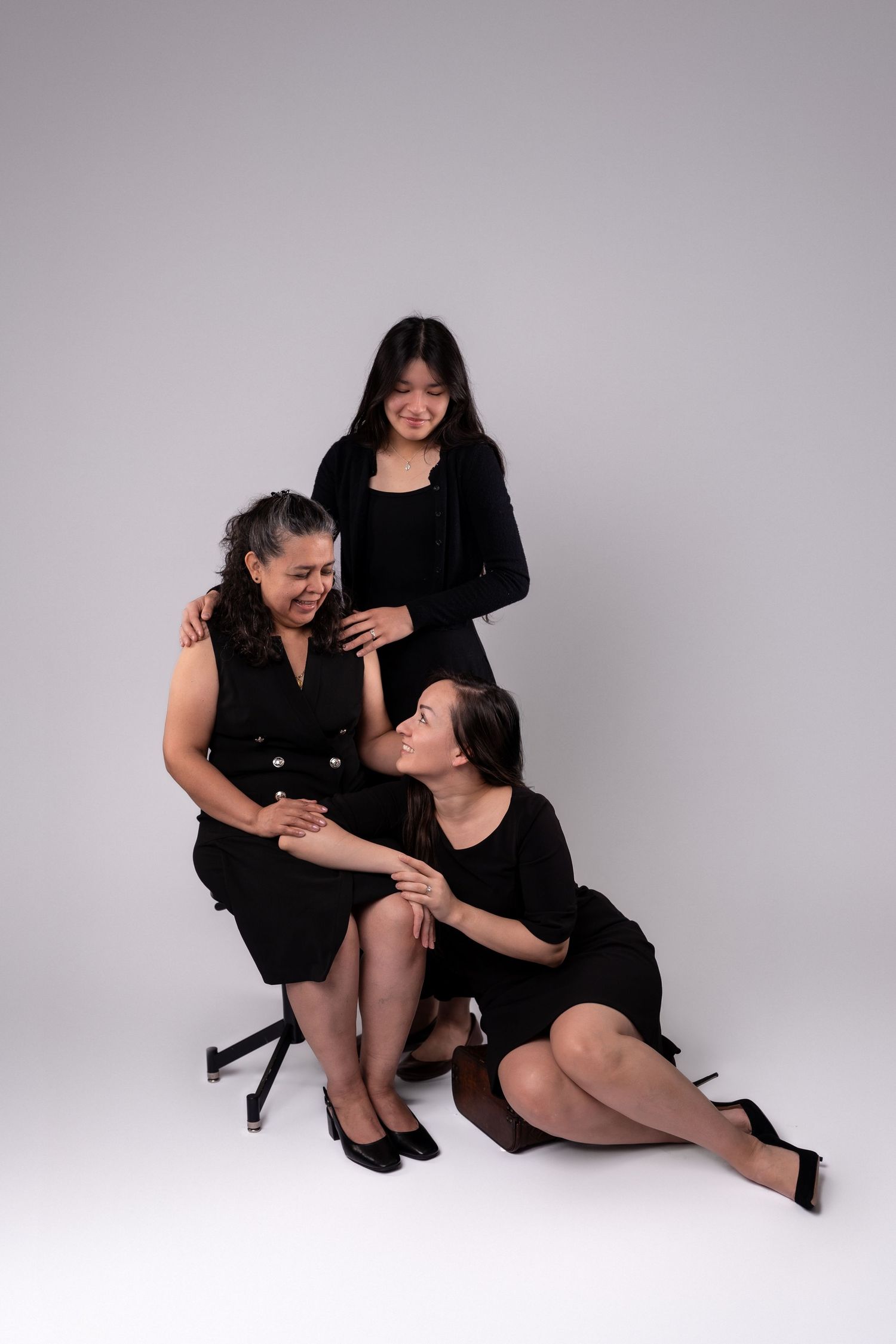 Studio portrait series showing intimate moments against grey backdrop.