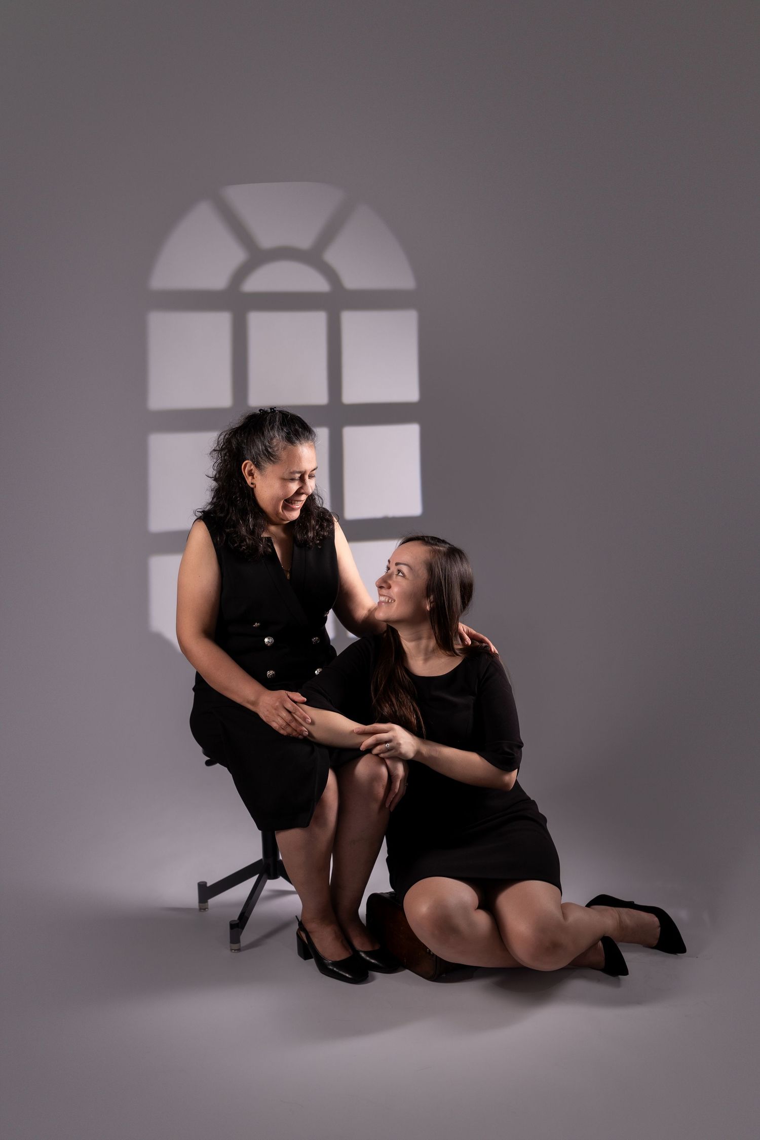 Studio photography with window light projections creating dramatic shadows.