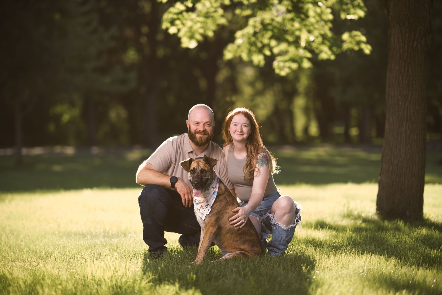 Family relaxing together on sunny grass in a park setting.