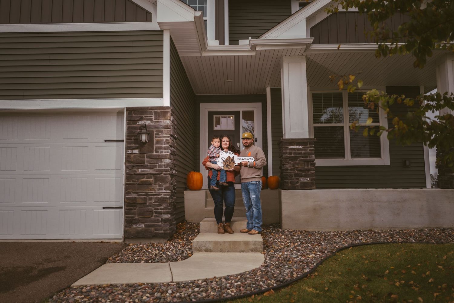 A family stands together on their home's front walkway.
