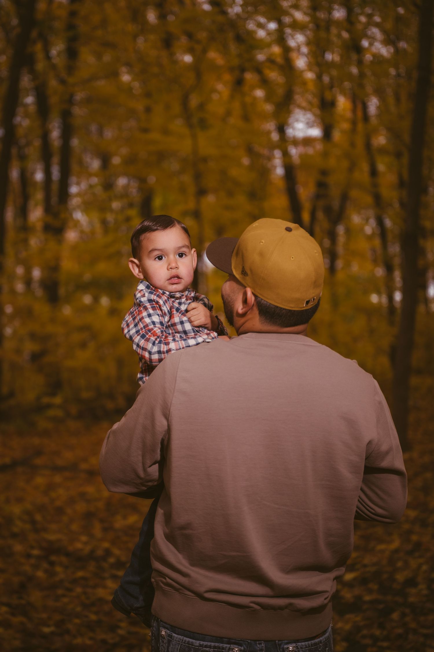 A candid autumn moment captured in a wooded setting with golden leaves.