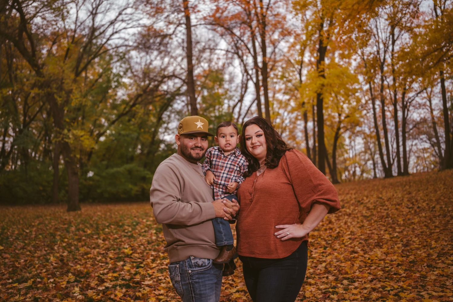 Candid family moments captured in a wooded area during peak fall foliage.