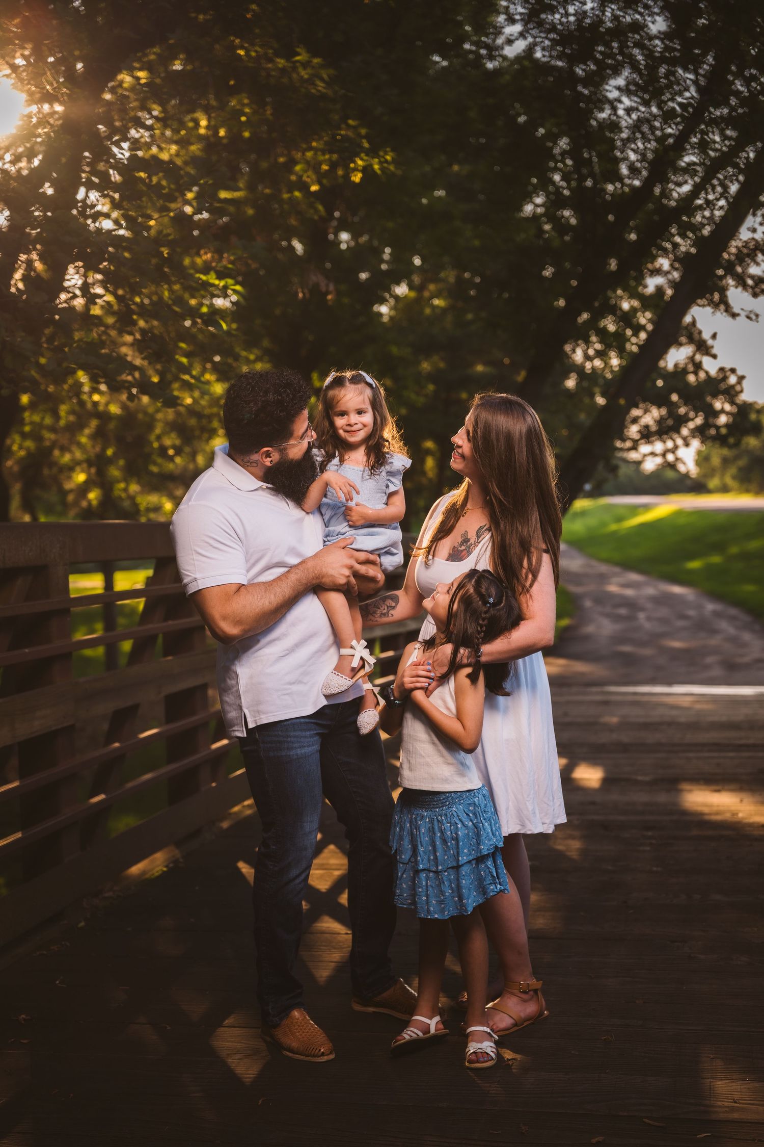 Candid family moment captured on a rustic bridge during sunset.
