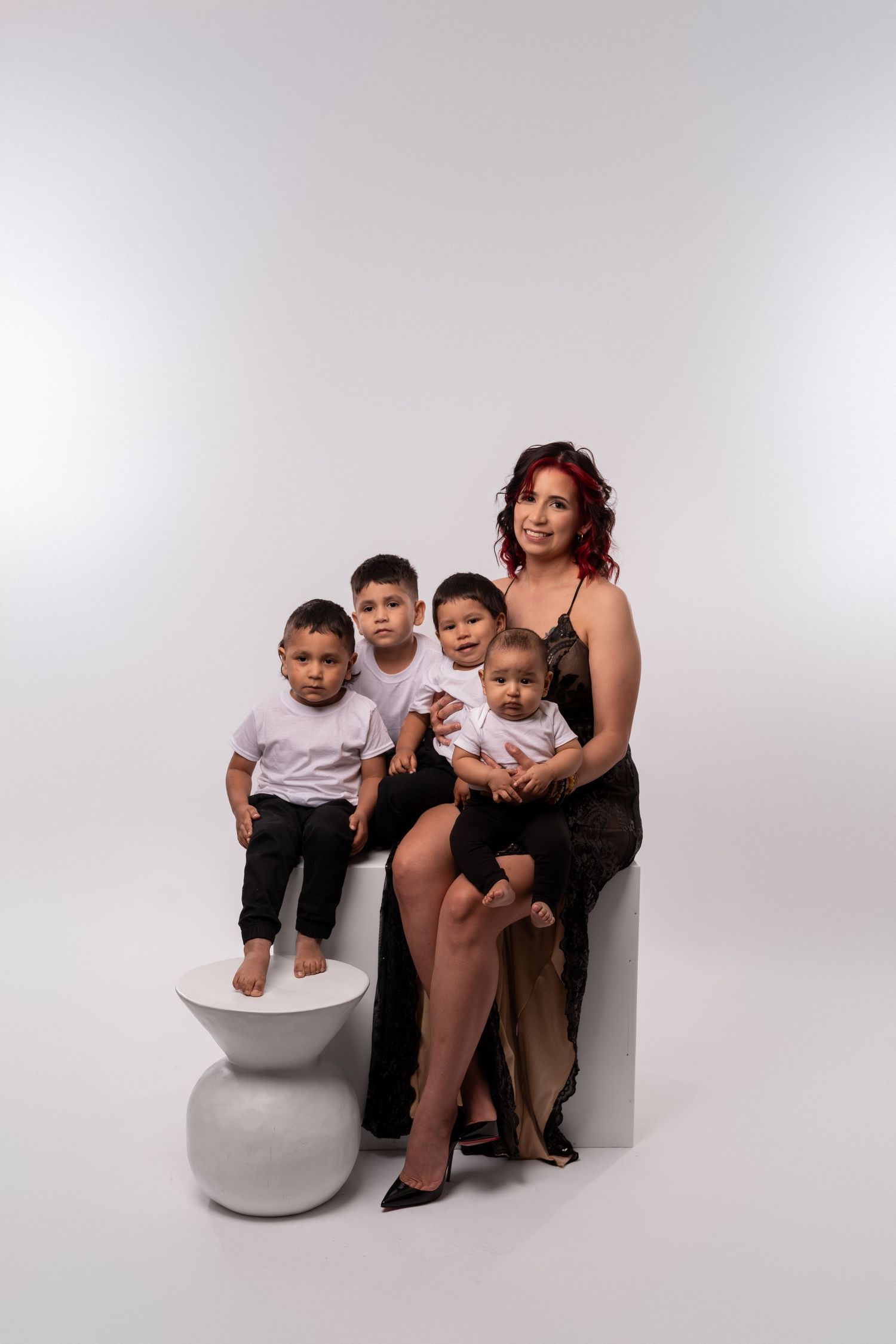 Family members pose on white platforms in coordinated black and white outfits.