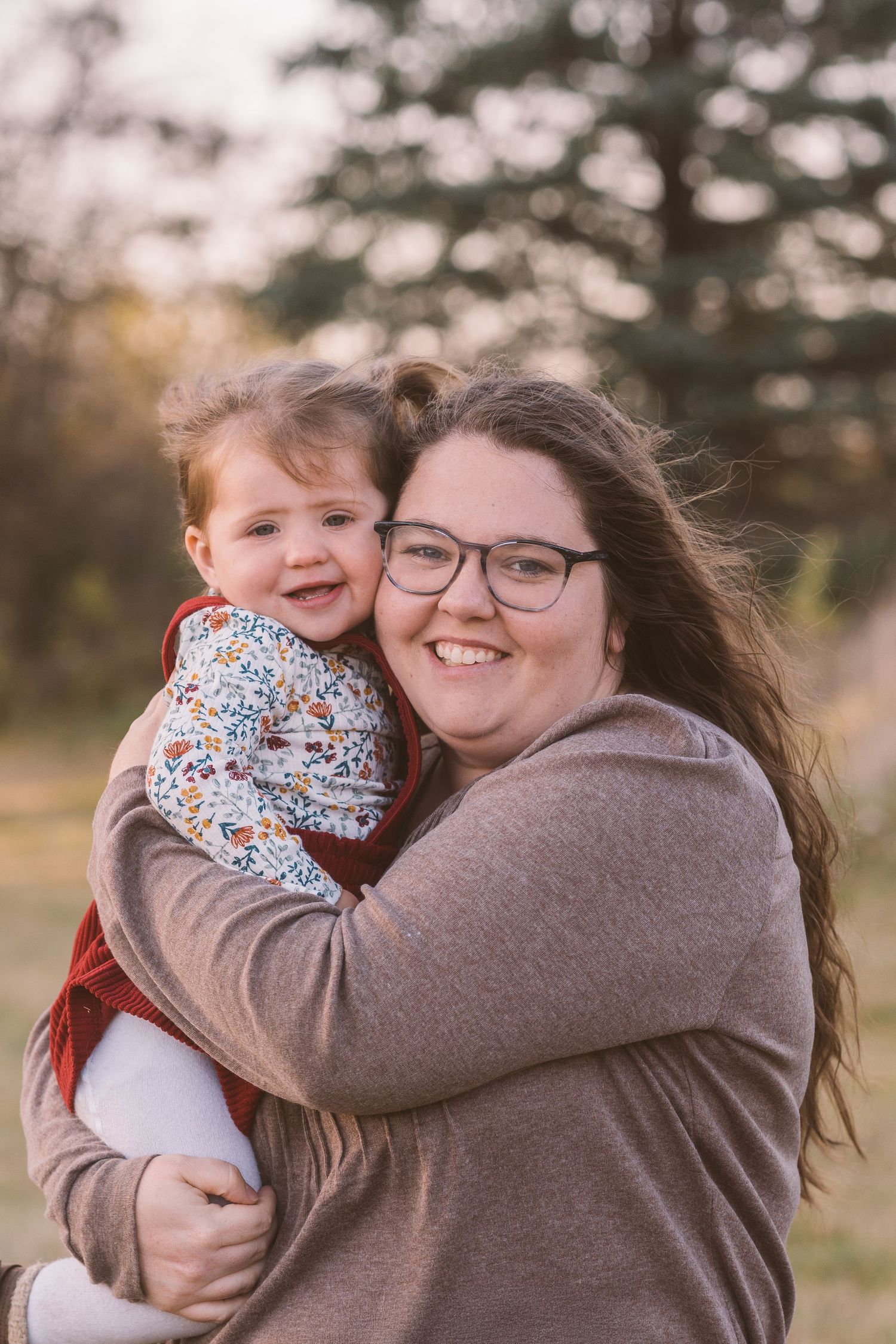 Joyful parent-child embrace captured during outdoor autumn photoshoot.