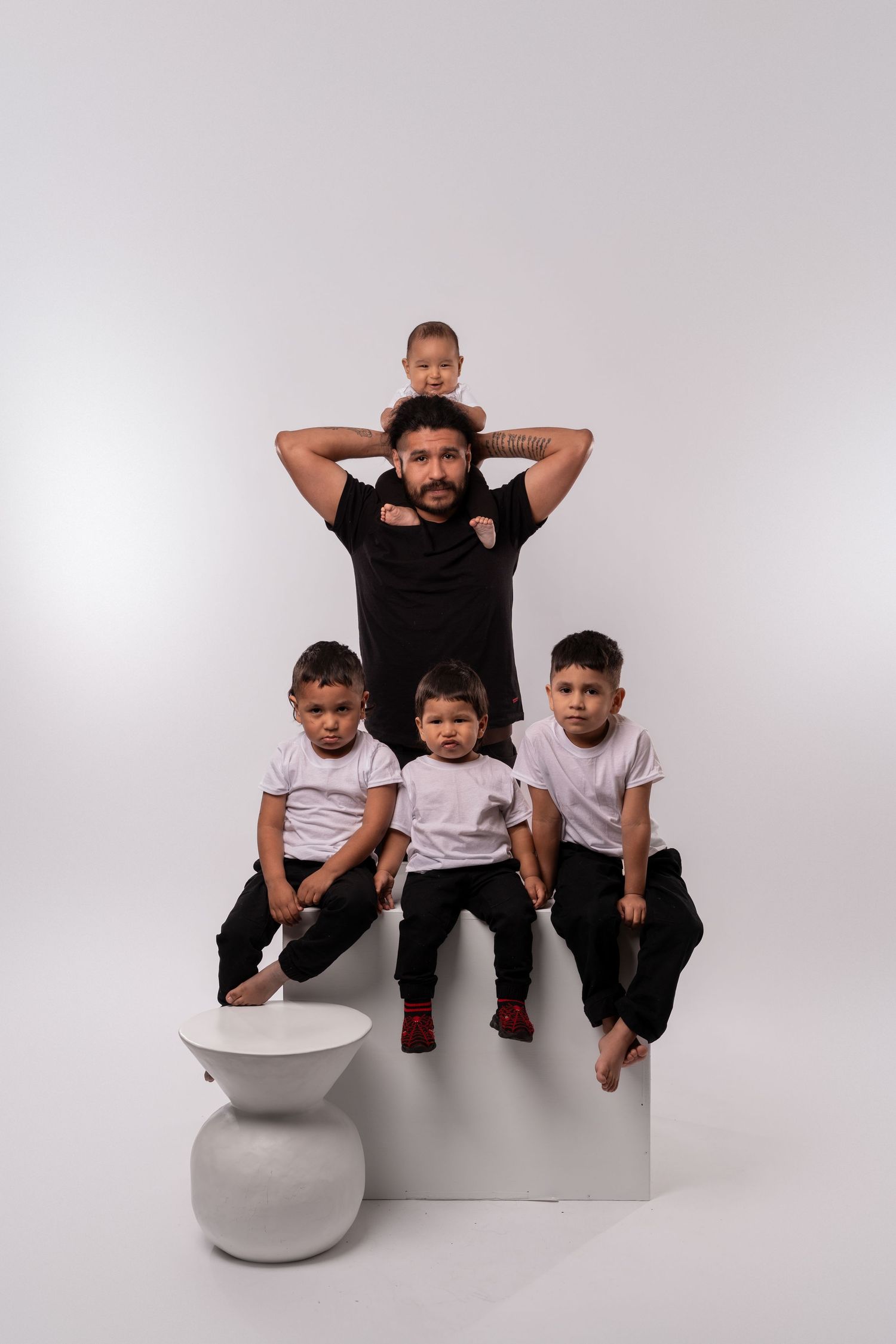 Group portrait with children and adults arranged on white geometric platforms.