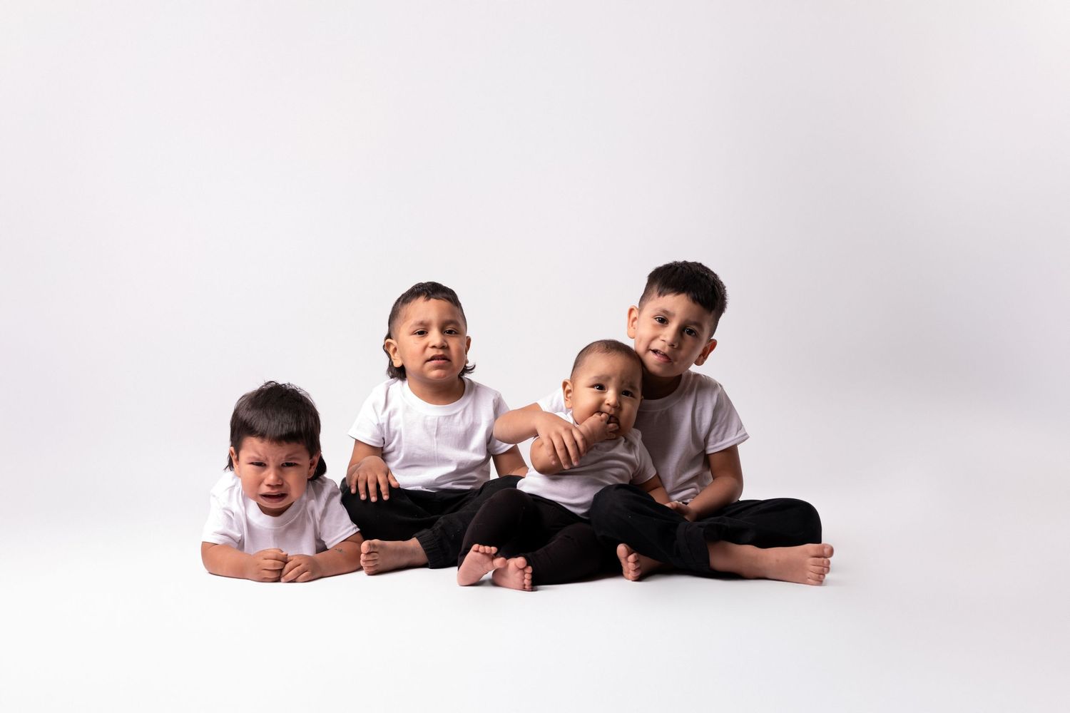 Casual family portrait with members arranged on white geometric platforms.