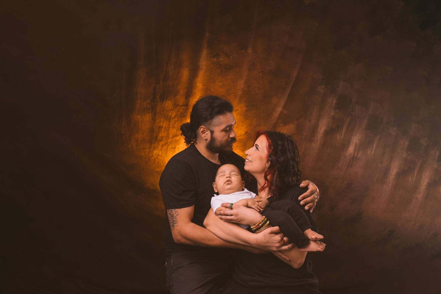 Family portrait series with dramatic amber lighting against dark background.