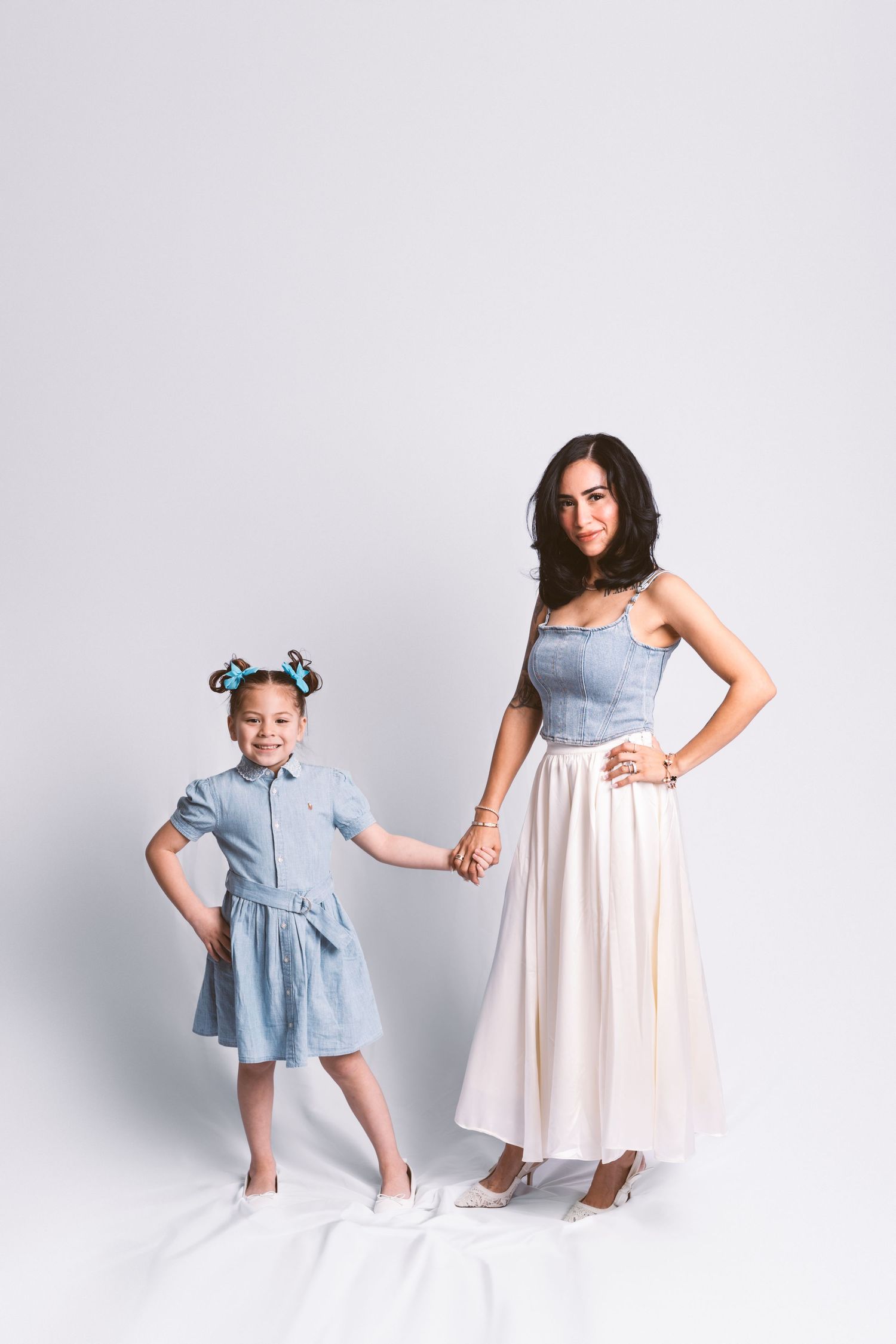A sweet family moment captured in a studio with coordinating blue and white dresses.