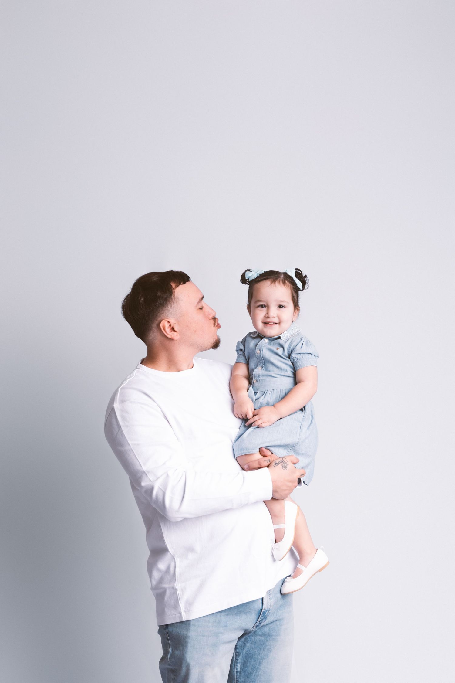 Heartwarming family portraits showing tender moments between parent and child in matching outfits.
