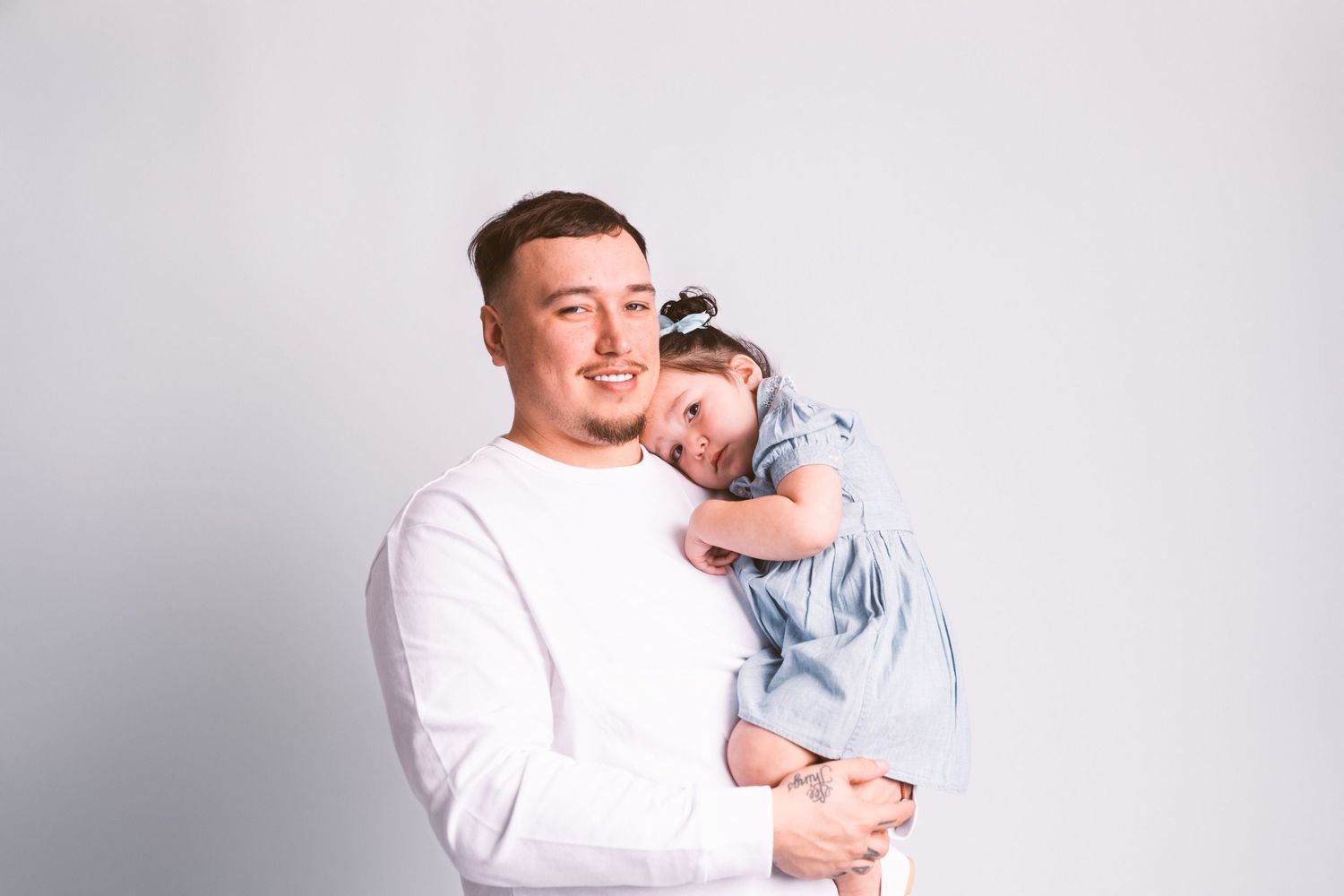 Sweet candid moments between parent and child wearing coordinated white and blue outfits.