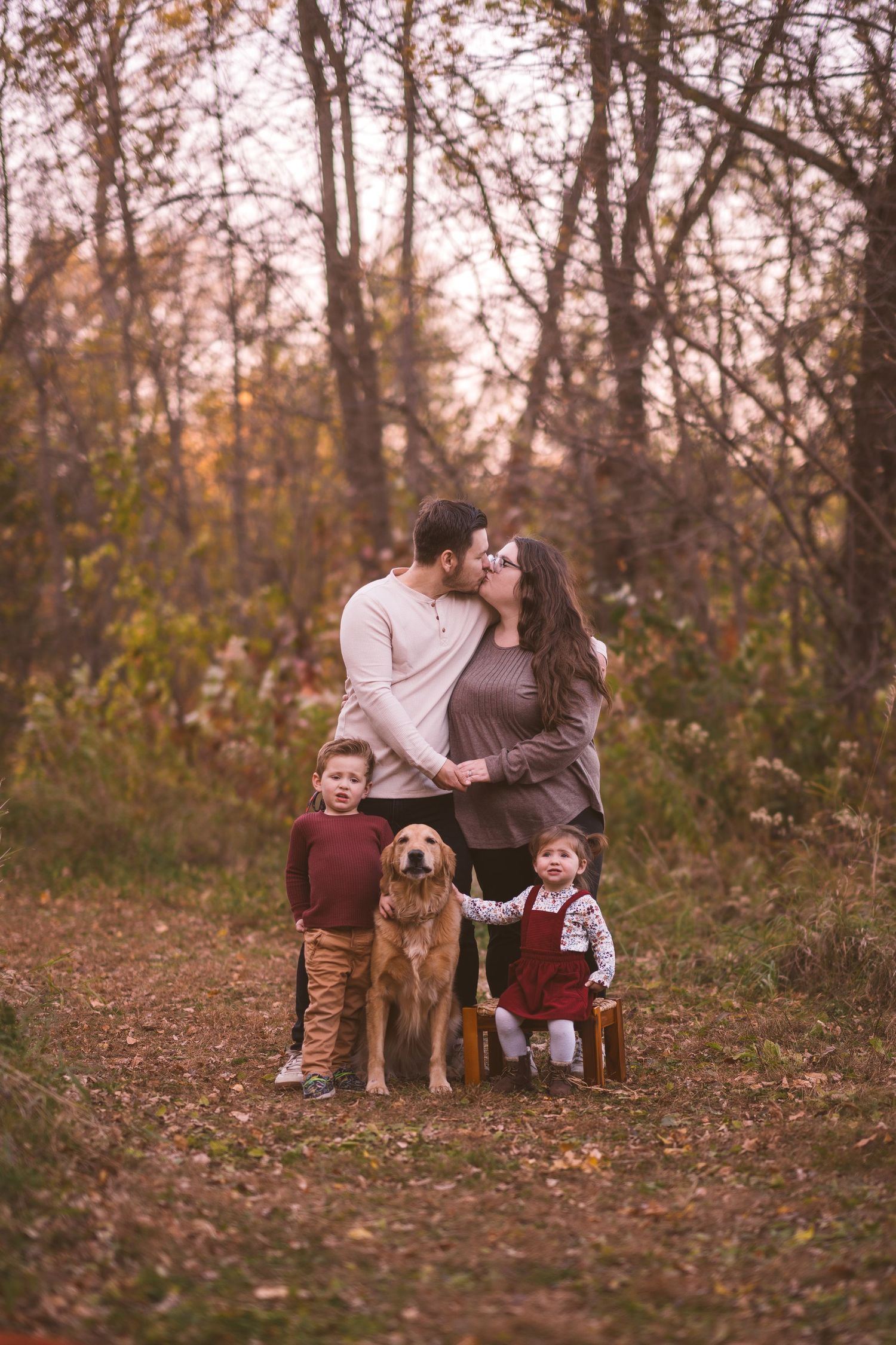 Family shares intimate moment together outdoors during fall photo session.