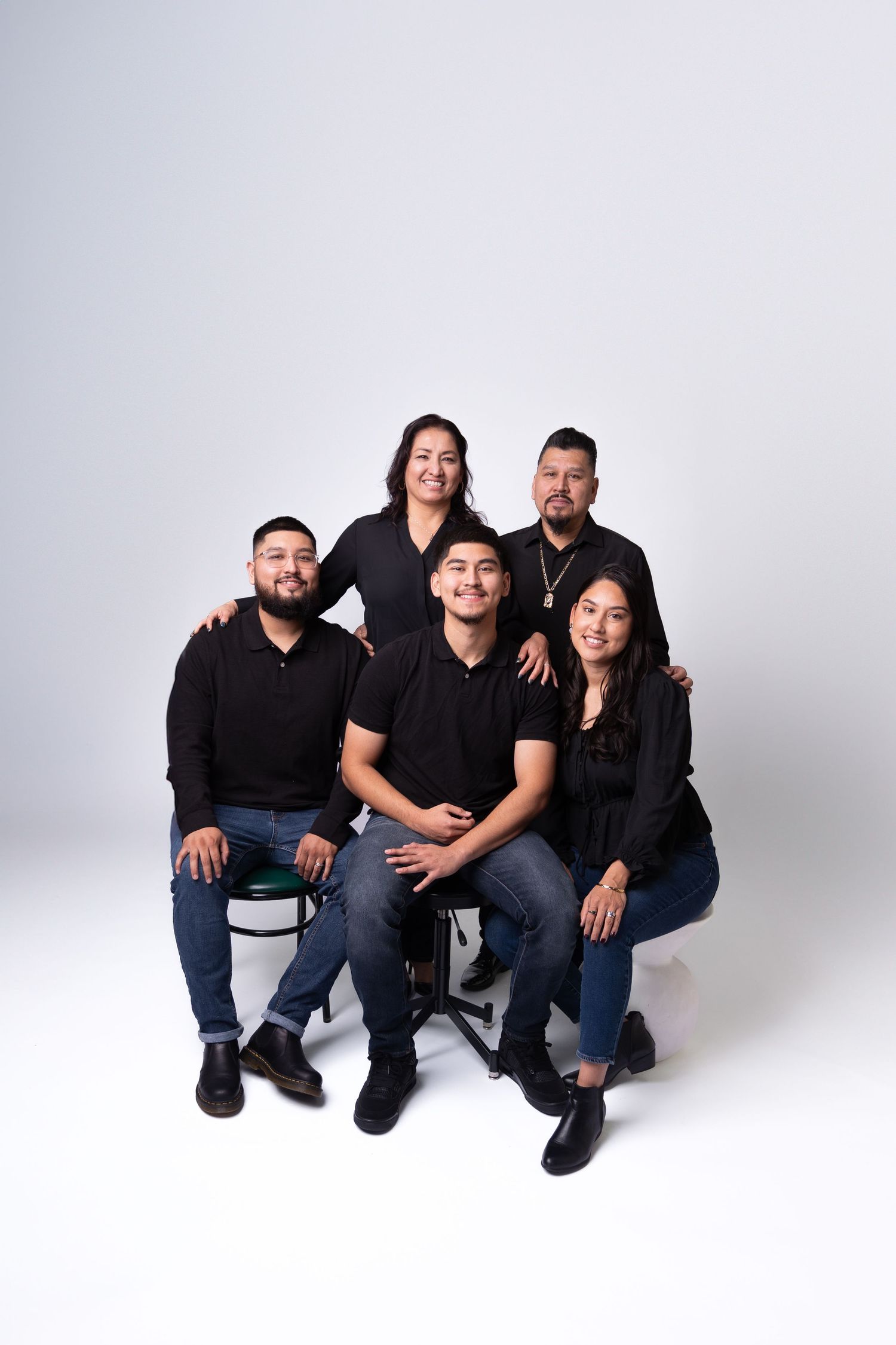 Group photo of people wearing black and blue casual attire against a white background.