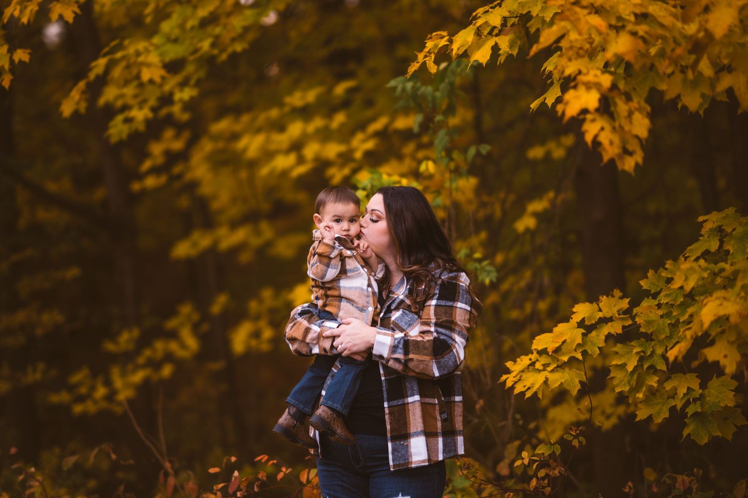 Warm autumn scene with family members in coordinated plaid outfits.
