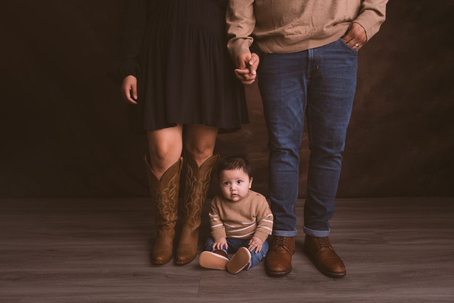Family photo session showing creative low-angle shots on dark wooden floor.