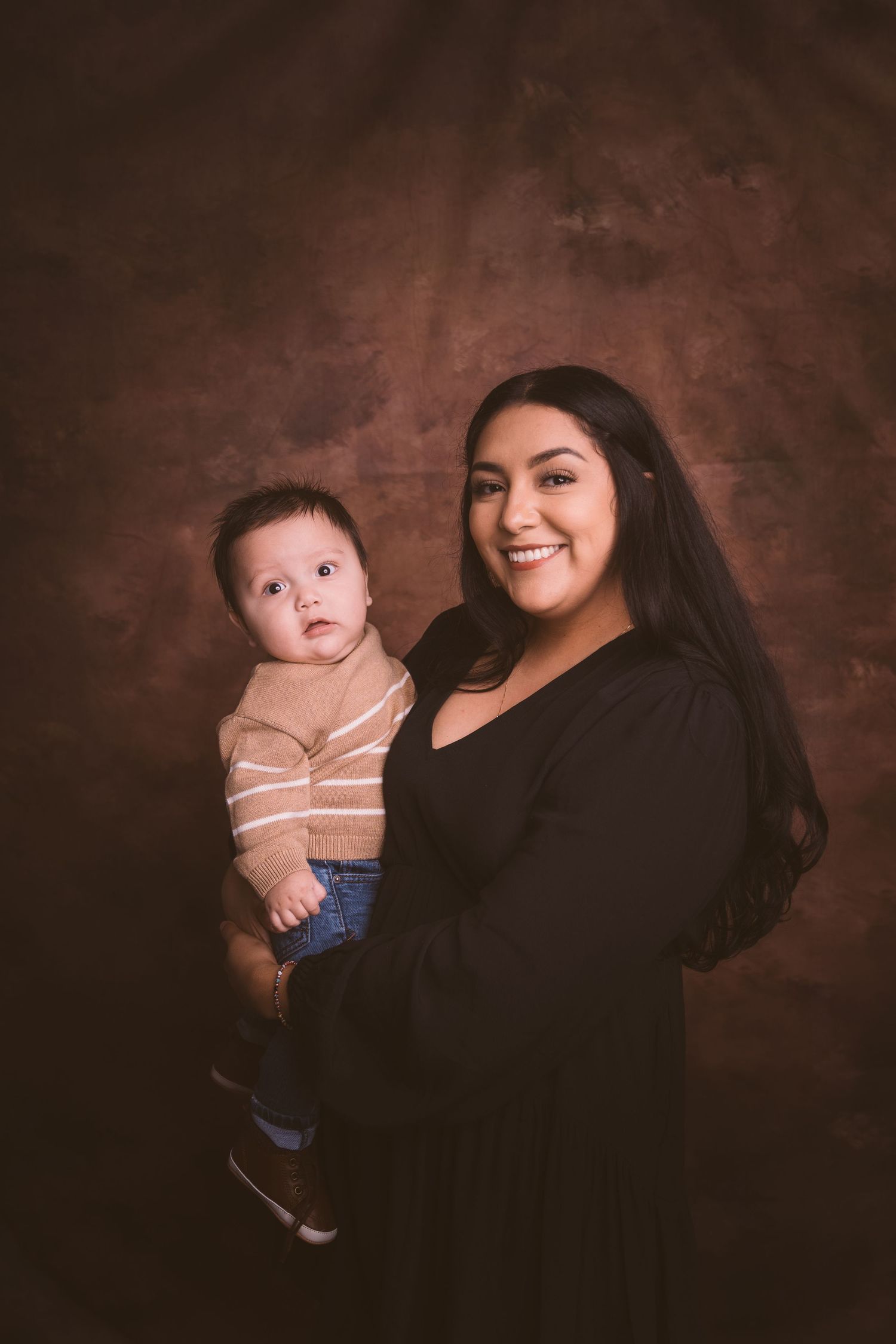 Studio portrait session featuring casual poses against textured brown background.