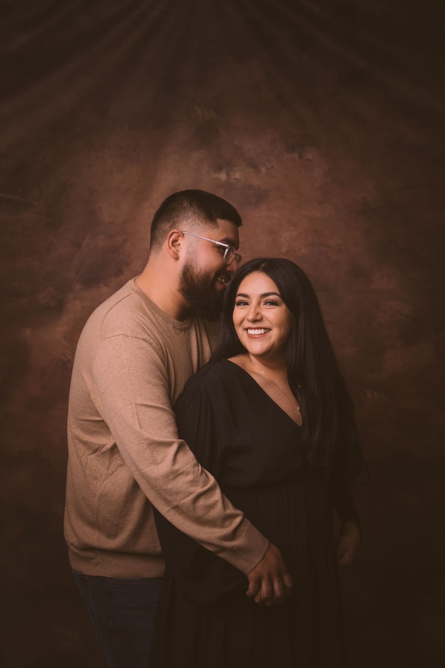 Romantic studio portraits of a couple sharing intimate moments against a dark backdrop.