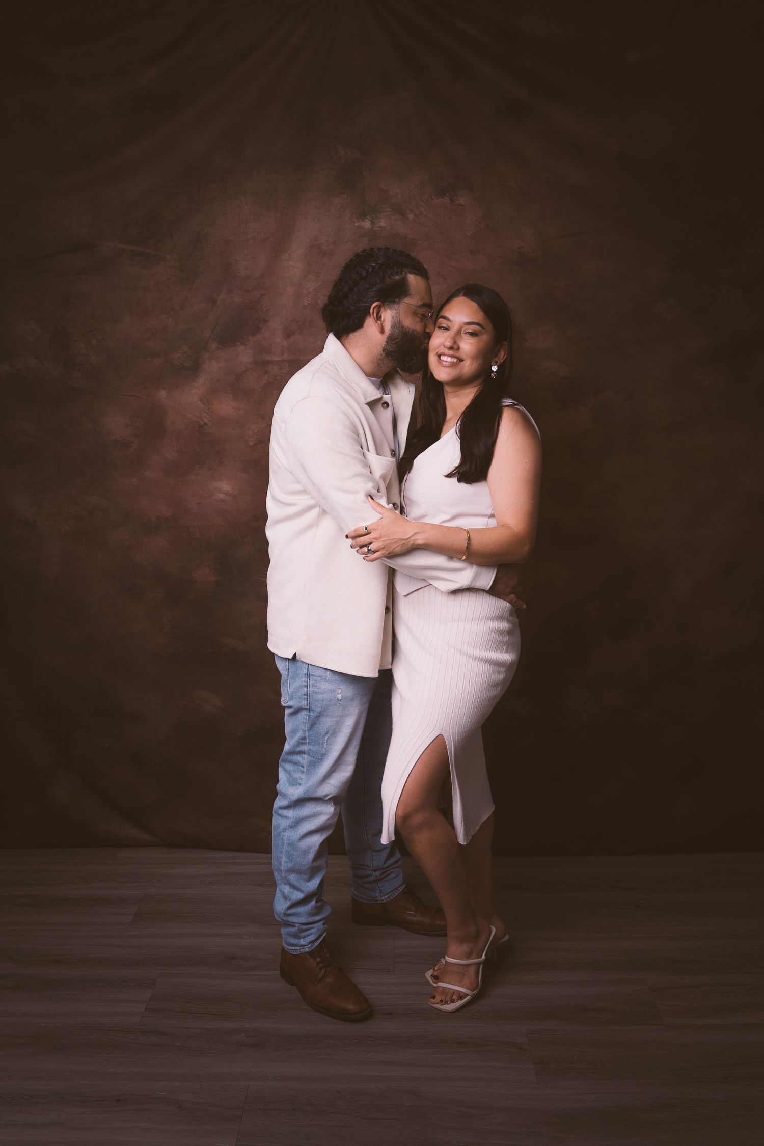 A candid moment of laughter and joy between a couple in coordinated light outfits.