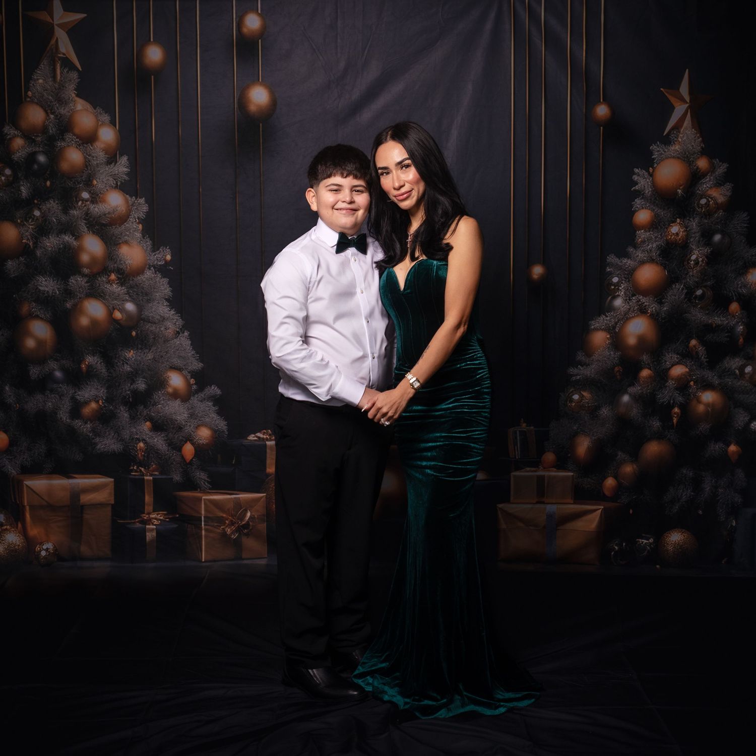 Elegant portrait of two people in formal wear against dark holiday backdrop.