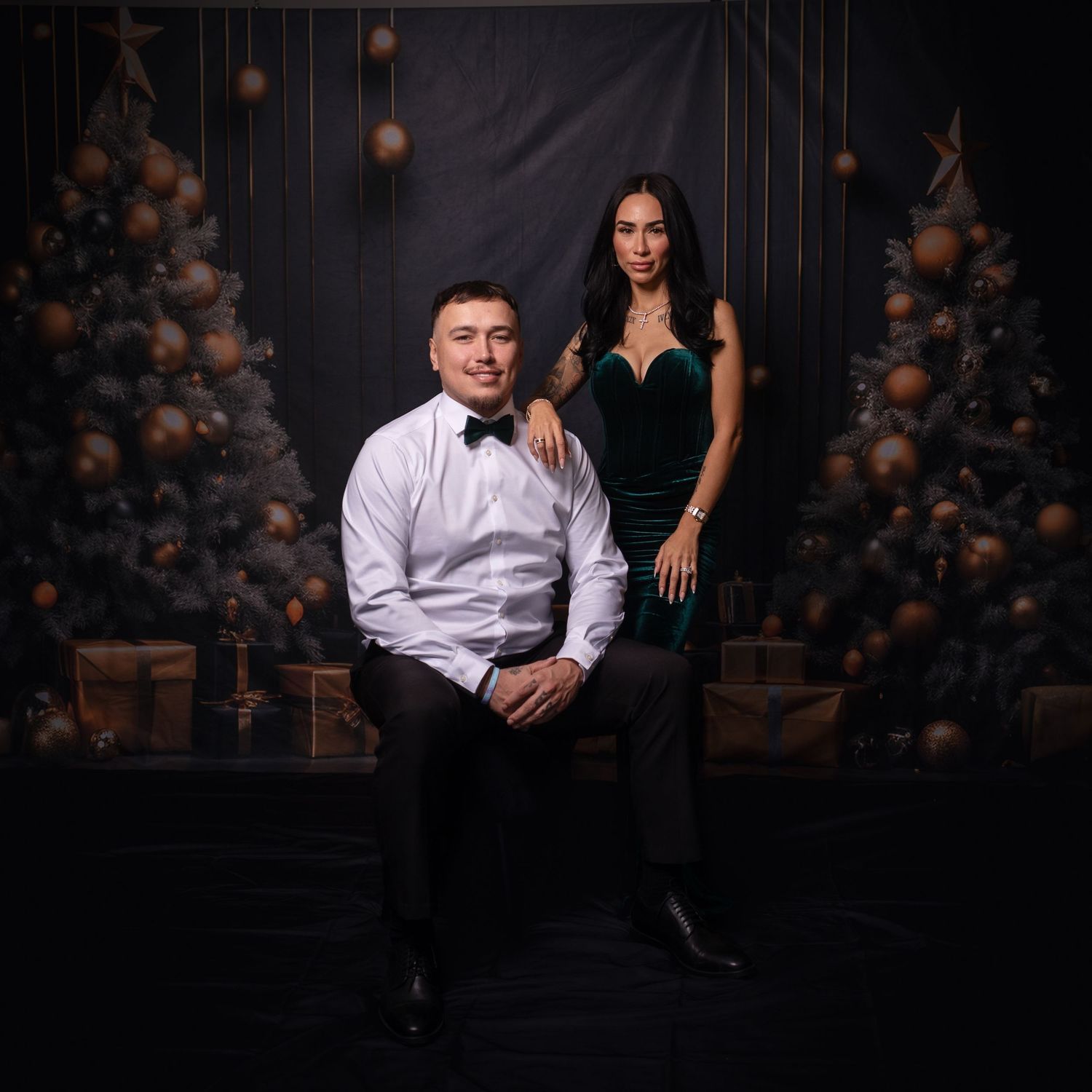 Elegant couple poses separately in studio with festive balloon and star decorations.
