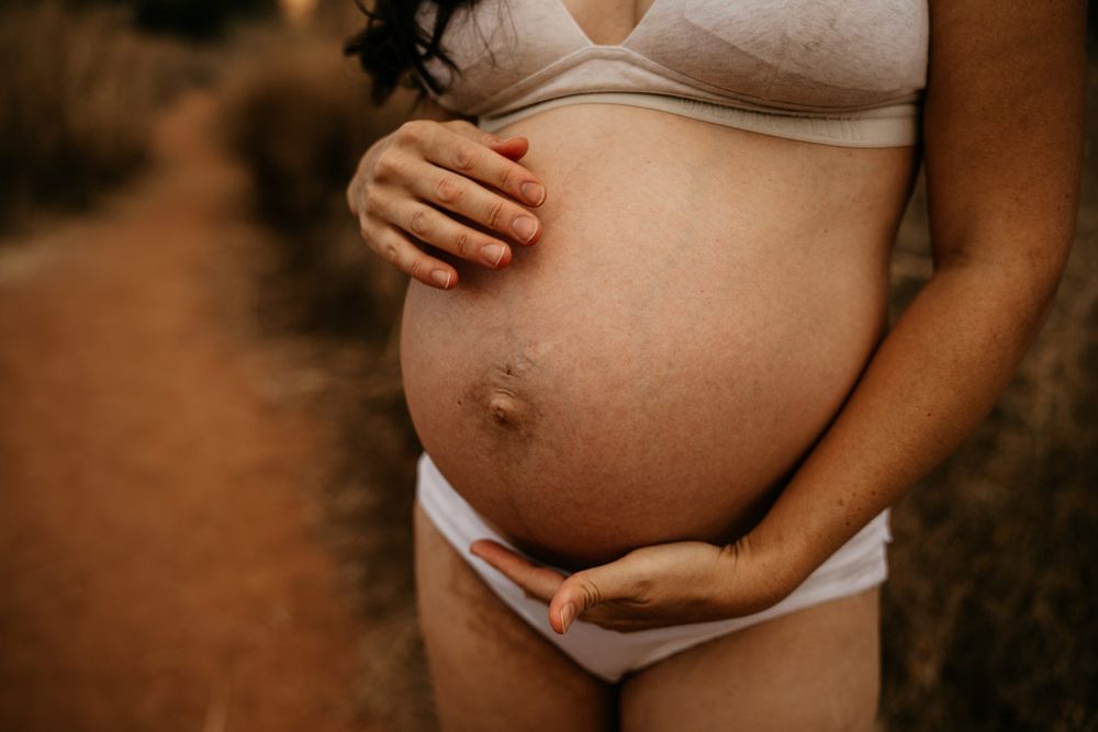 Intimate black and white maternity photograph showing baby bump.