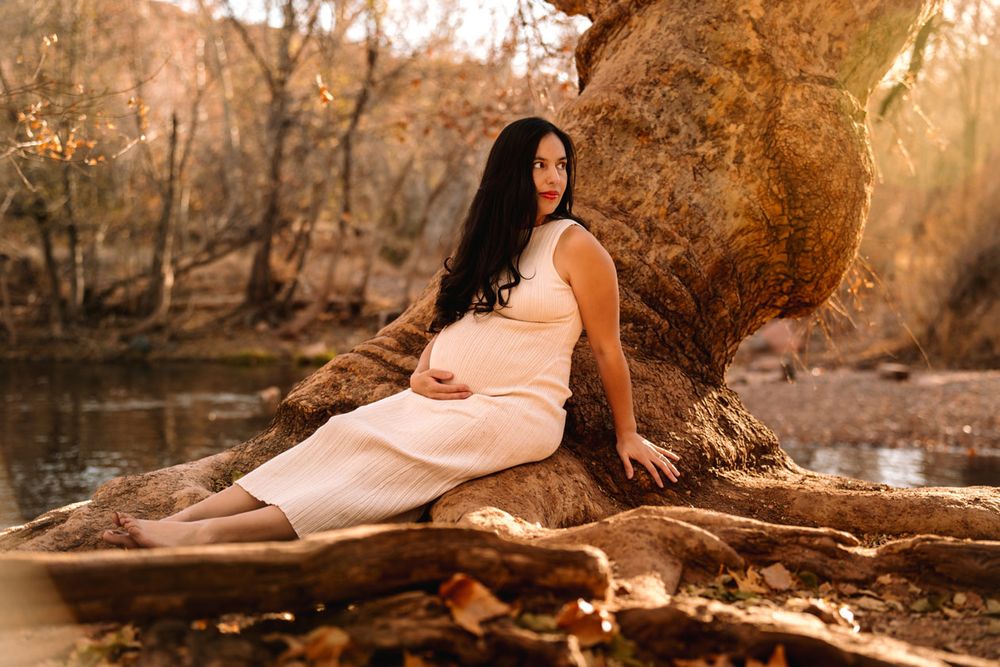Serene maternity photo by water with autumn colors.