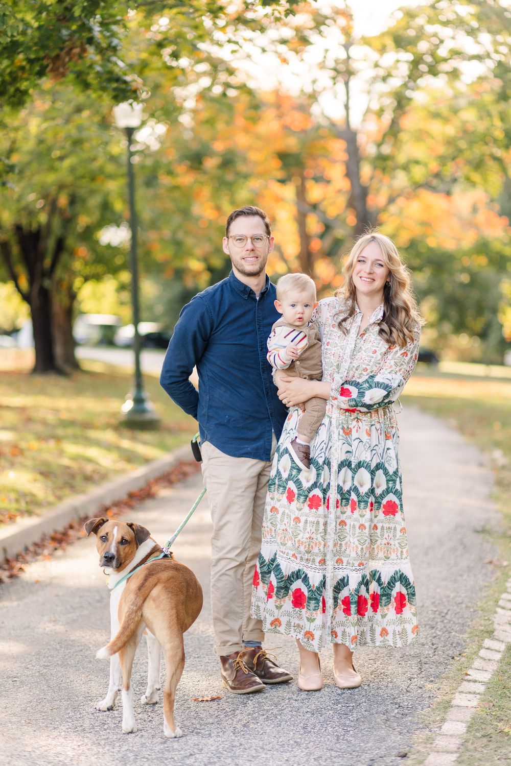 A family of three smile with their dog at Forest Hill Park in Richmond, Virginia.