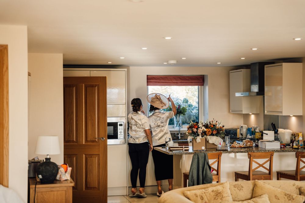 People preparing in a modern kitchen with natural light streaming through windows.