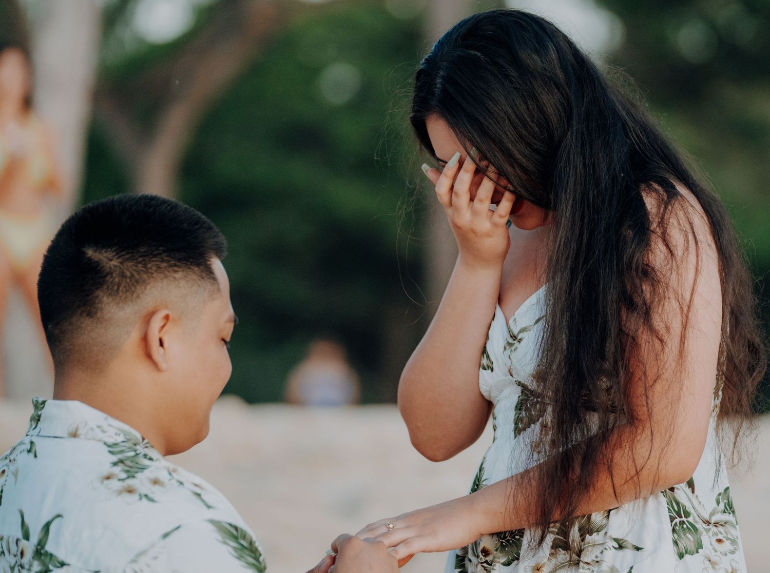 Emotional reaction during a surprise beach proposal.