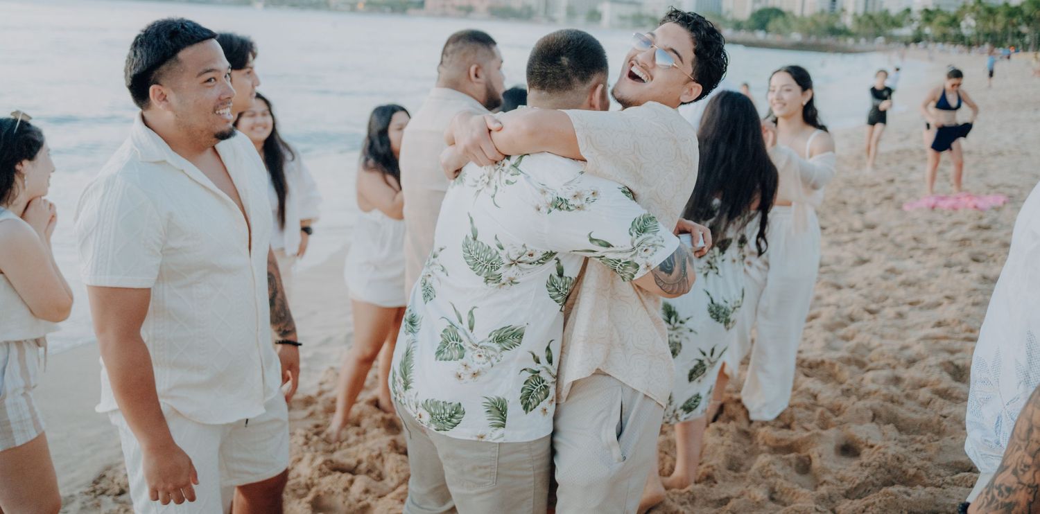 Friends and family gathering on beach to celebrate special moment.