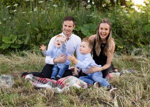 Family enjoying a picnic together in a wildflower meadow during summer.