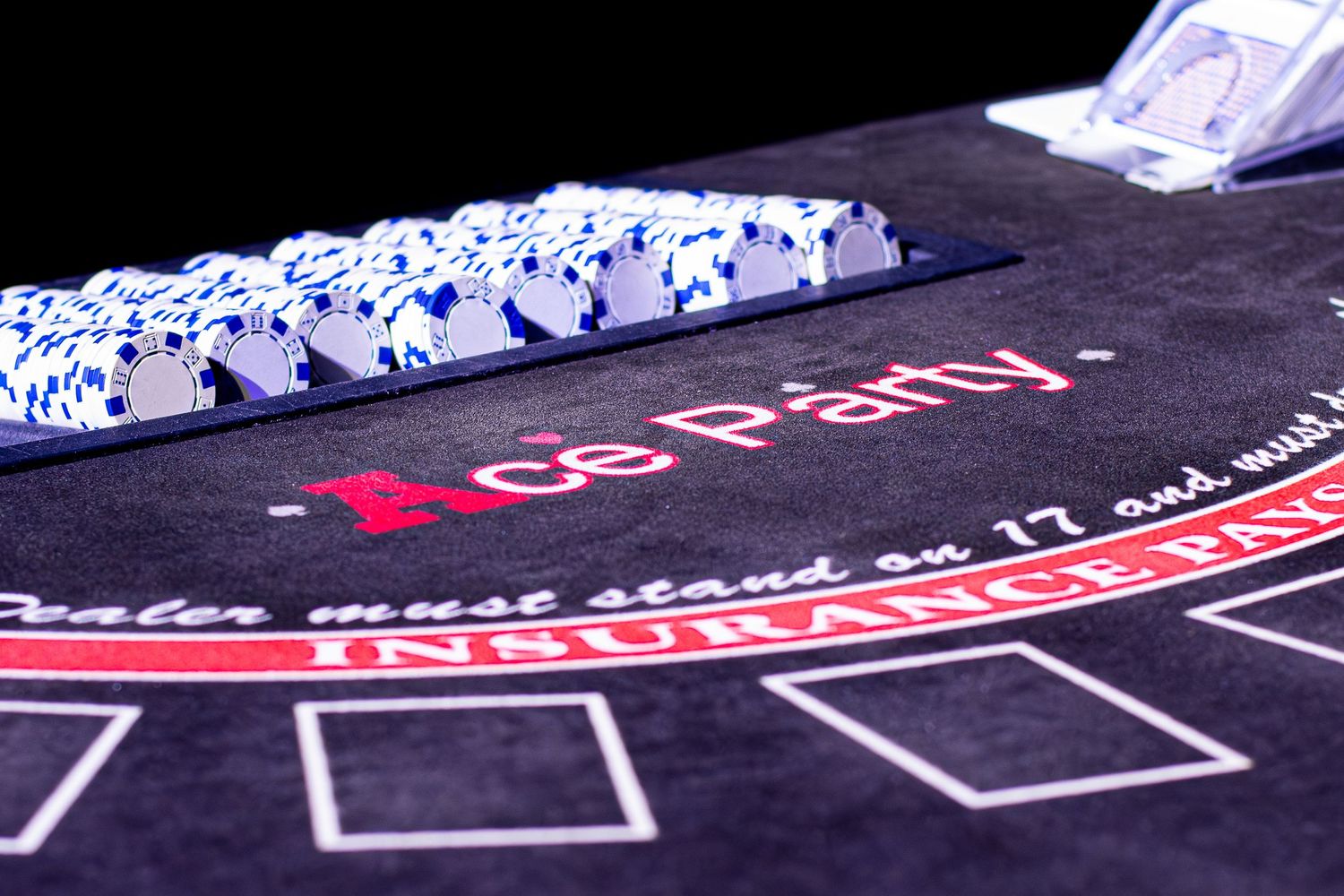 Close-up view of casino blackjack table layout with red and white markings.