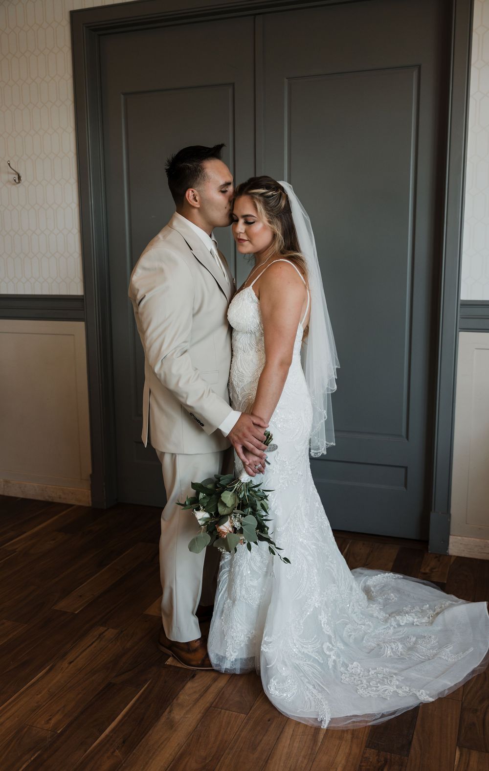 A series of intimate wedding photos capturing a couple's tender first look moment against a dark grey door.