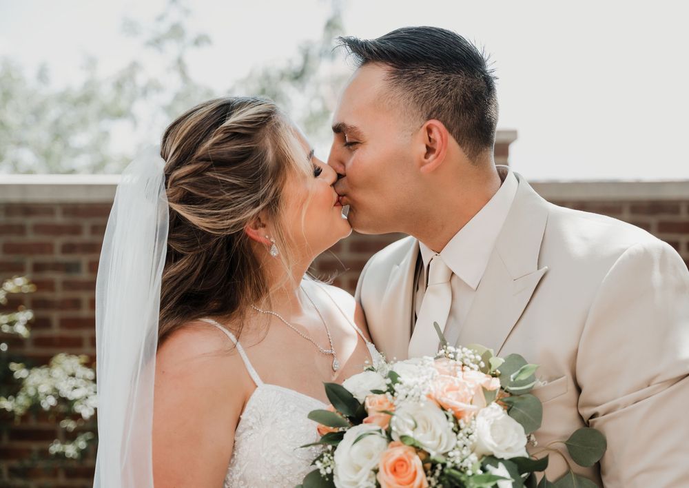 A romantic wedding couple shares tender moments in a series of photos with peach and white floral accents.