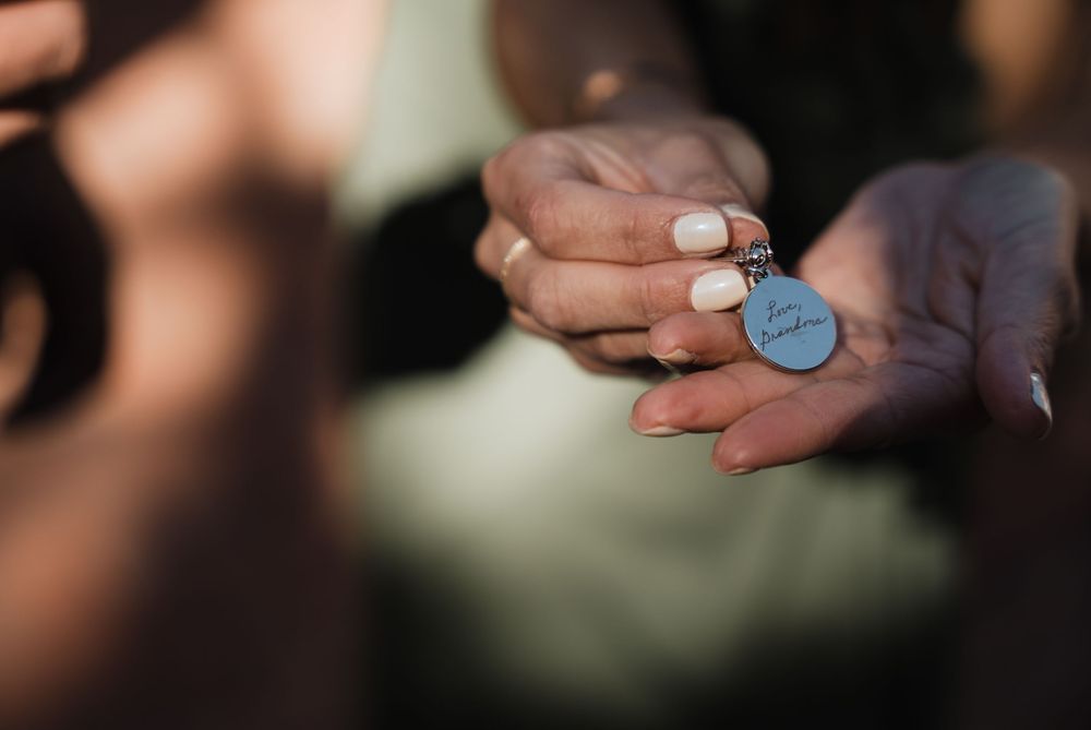 A hand holds a small blue circular token or coin against a blurred background.