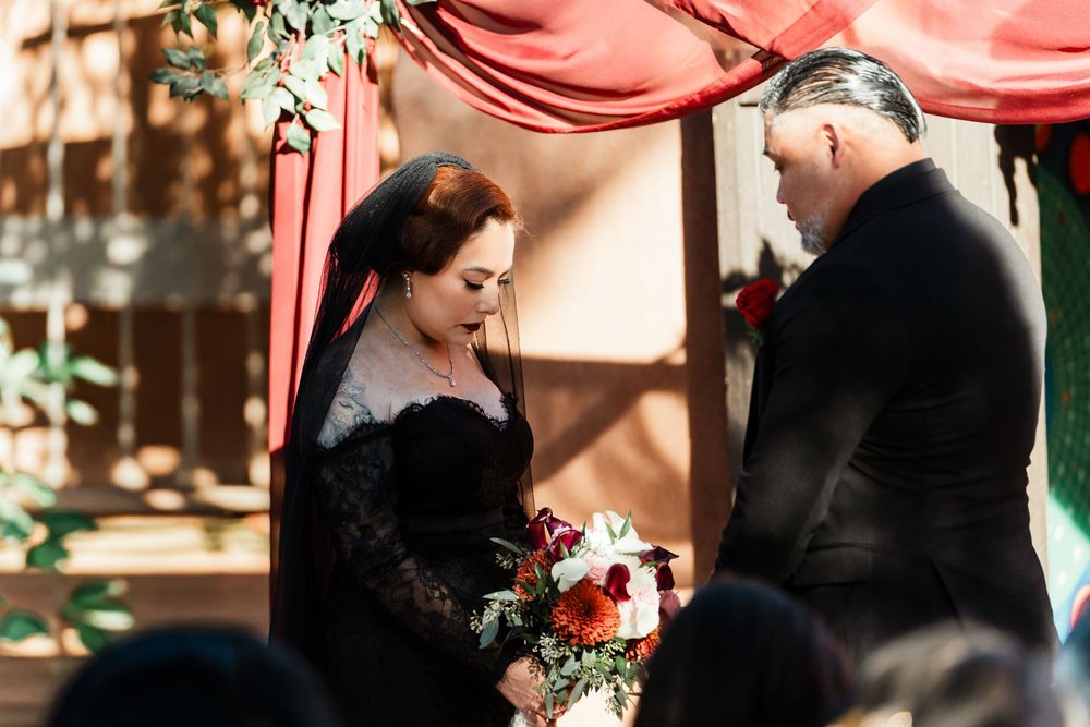 A couple in wedding attire shares a tender moment during their outdoor ceremony.