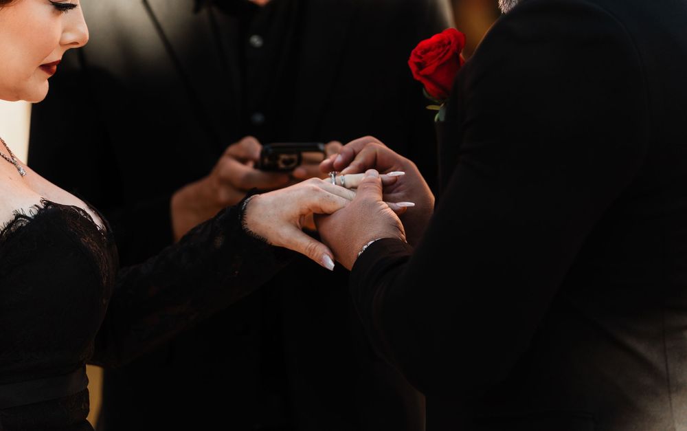A person's hands hold a smartphone while using a mobile payment app in a dark setting.