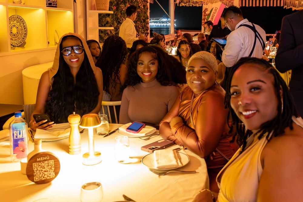 People enjoying a lively dinner gathering at a restaurant with warm lighting and a festive atmosphere.