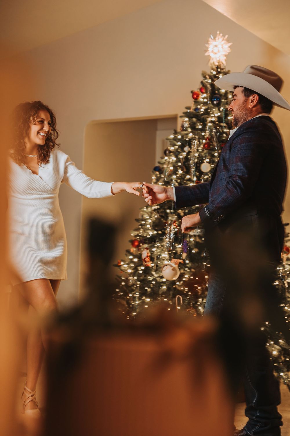 A romantic sequence of dance moves captured in front of a glowing Christmas tree with warm ambient lighting.