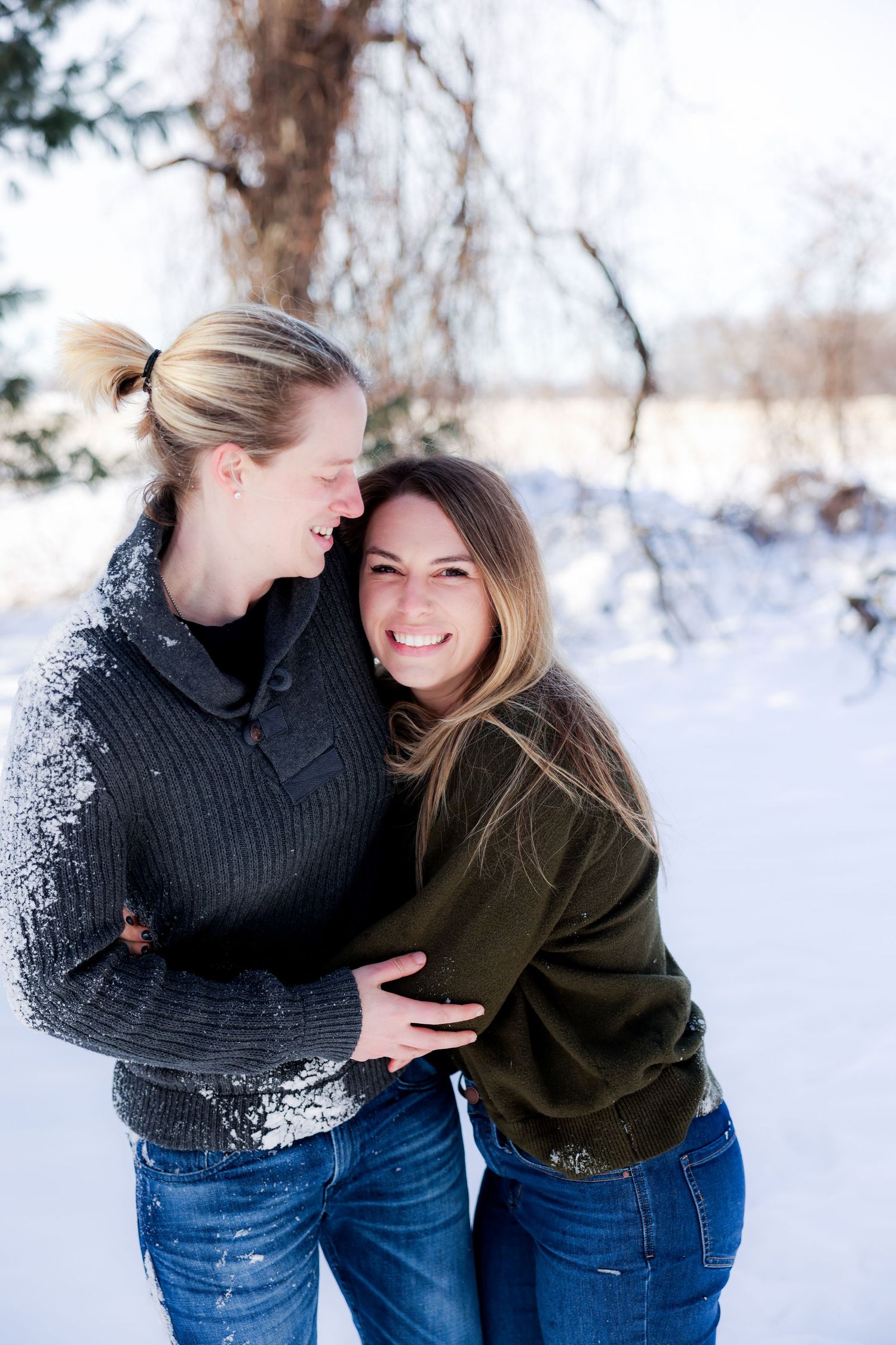 A couple and their Australian Shepherd dog share joyful moments together on a white bed during a photo session.