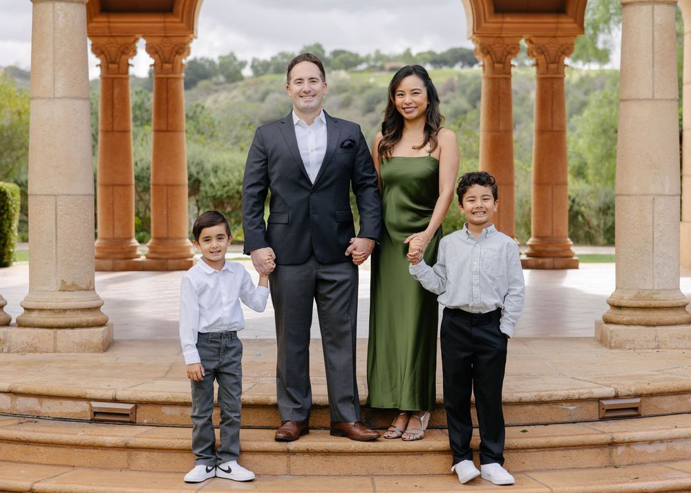 A series of outdoor photos showing a family gathering under a stone gazebo with pillars in a garden setting.