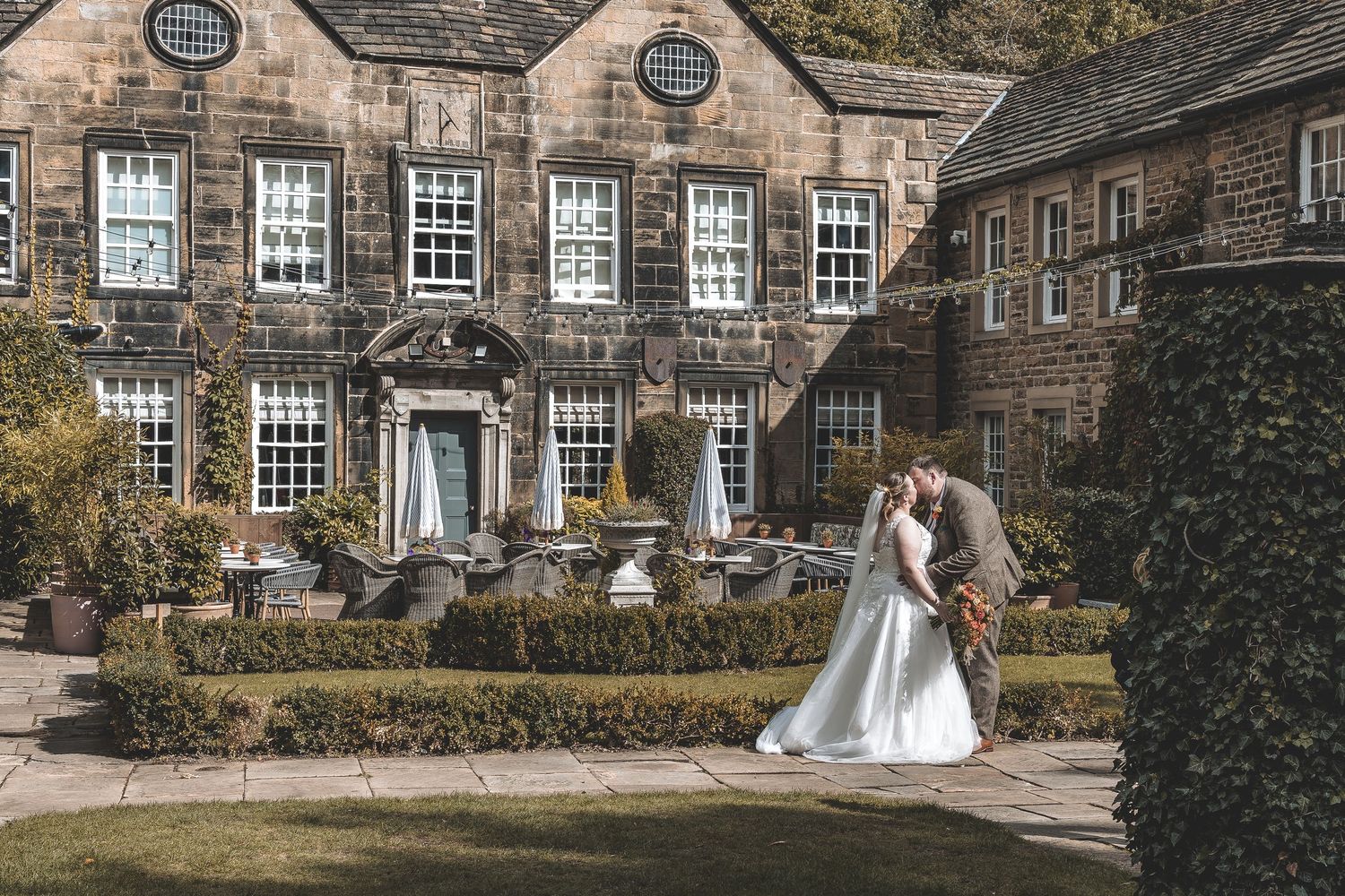 A relaxed couple wedding photo of bride and groom in front of their Yorkshire wedding venue.