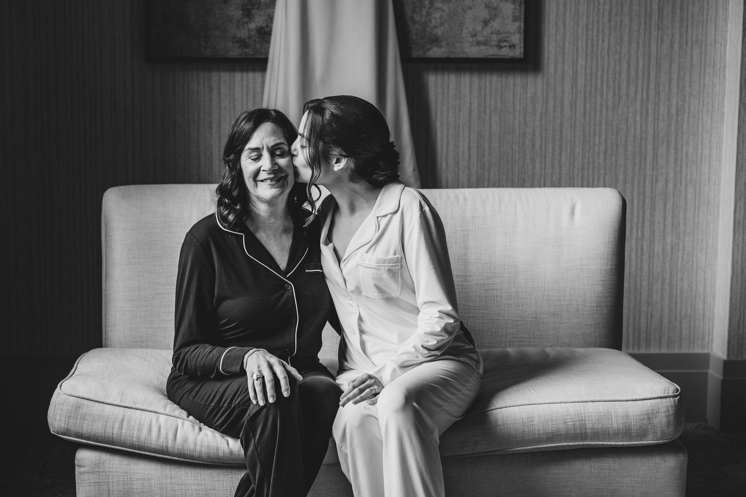 Candid black and white moments of wedding preparations in a sunlit room.