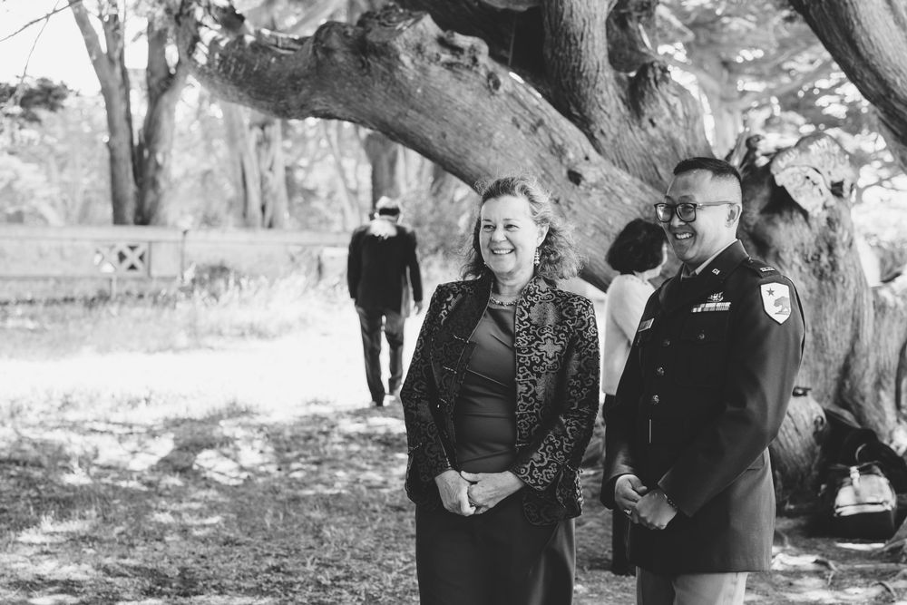groom look on towards bride with friend in a sutro heights elopement.