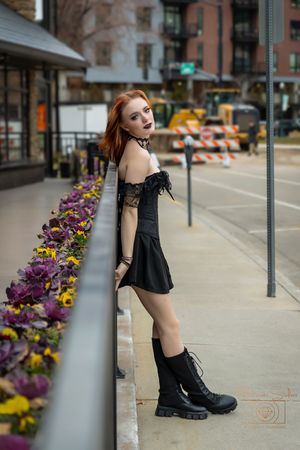 girls leaning on railing with flowers behind