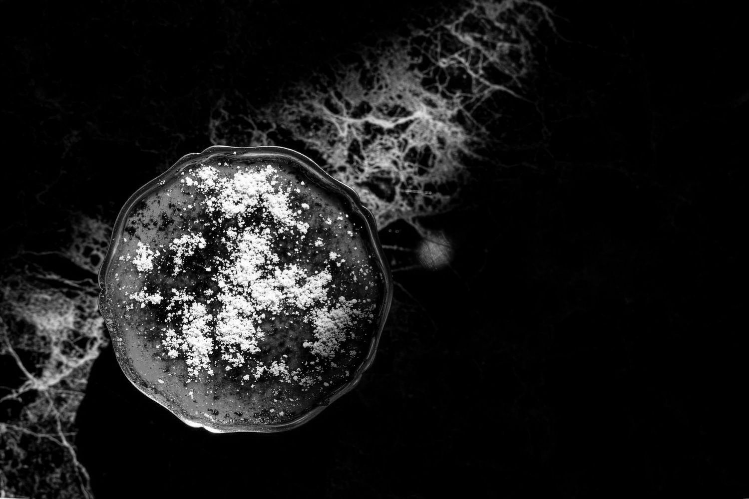 Abstract black and white aerial view of ocean waves with foam.