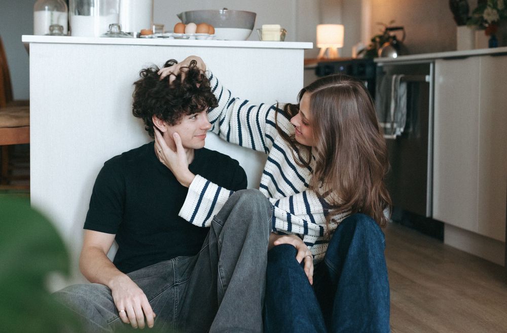 A couple sharing playful moments in a modern minimalist home setting.