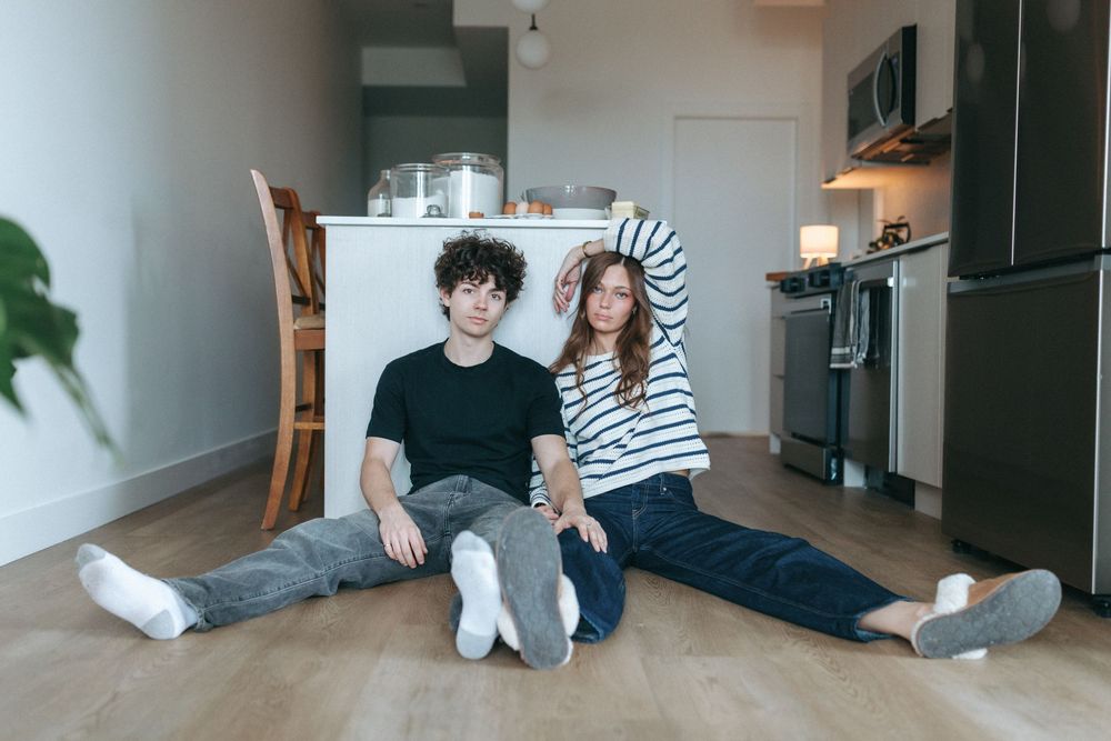 Modern minimalist room with couple relaxing on floor near window.